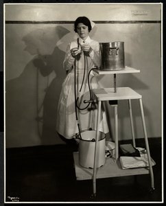 Una enfermera demostrando un aparato especial con tubos y cubos de suministro y desecho en el Sloan Maternity Hospital, Broadway y la calle 168, Nueva York, 1932